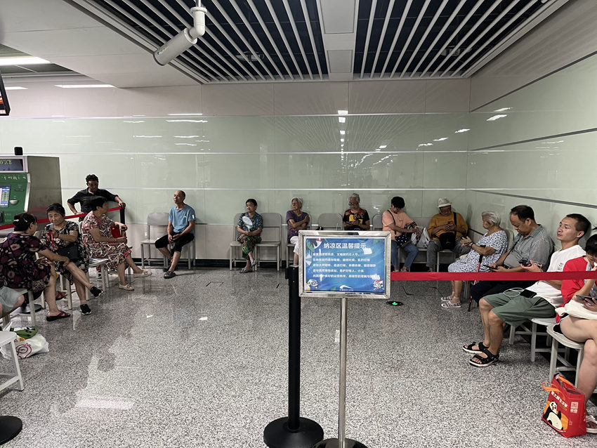 车站的纳凉区域市民或闭目养神,或小声攀谈。人民网记者 郭莹摄