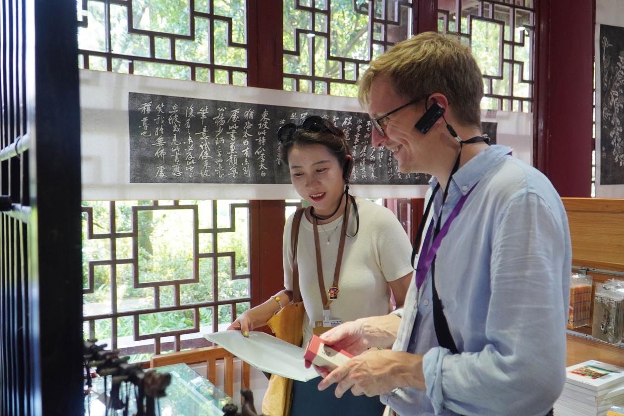 3、2024“一带一路”媒体合作论坛联合采访调研行成员在三苏祠挑选文创产品。人民网 赵祖乐摄