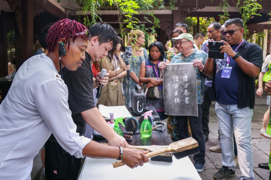 1、2024“一带一路”媒体合作论坛联合采访调研行成员在三苏祠体验拓印技艺。本报记者 伊霄摄