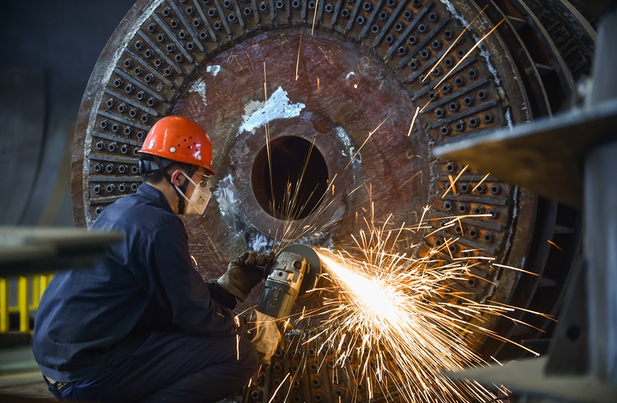 洛阳市中信重工铆焊车间内，工人正在加工打磨处理一批出口的矿用磨机产品订单。黄政伟摄