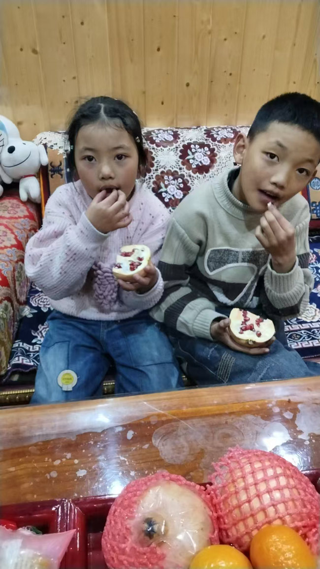 高原上的小朋友吃到了石榴。受访者供图