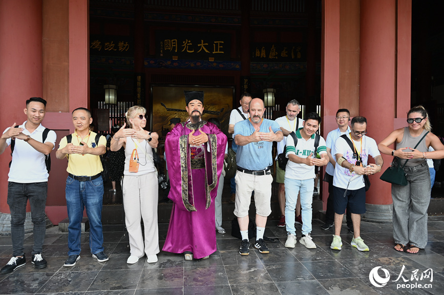 旅行商代表跟“包大人”学习拱手礼。人民网记者 王玉兴摄