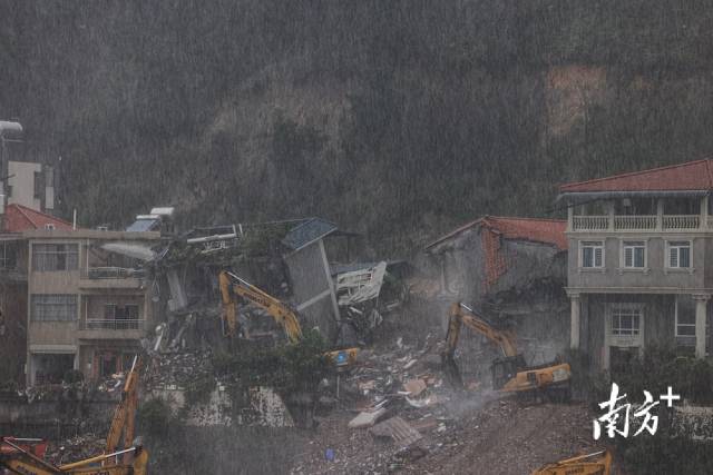 8月7日14时许，广州白云区山体滑坡现场被破除房屋的清理工作正在进行。该区域受暴雨影响，救援人员仍在雨中加紧救援。  