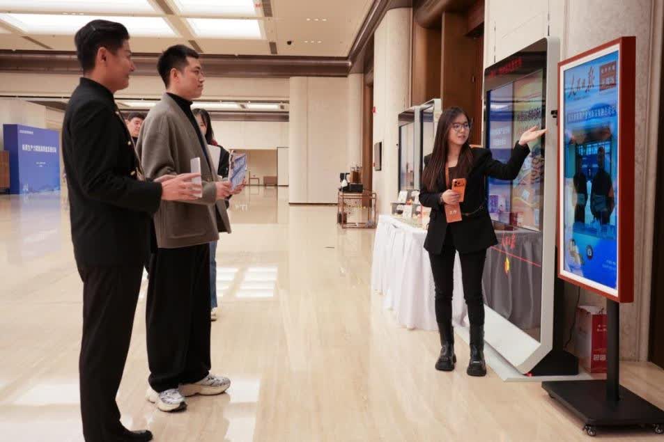 图：与会嘉宾体验人民日报电子阅报栏拍照打卡功能。人民日报数字传播 张乐华摄2.jpg