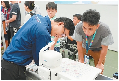 2026年IBTE河内国际潮玩展上，当地市民与中国制造的人工智能象棋机器人对弈。 本报越南分社 阮氏梅香摄