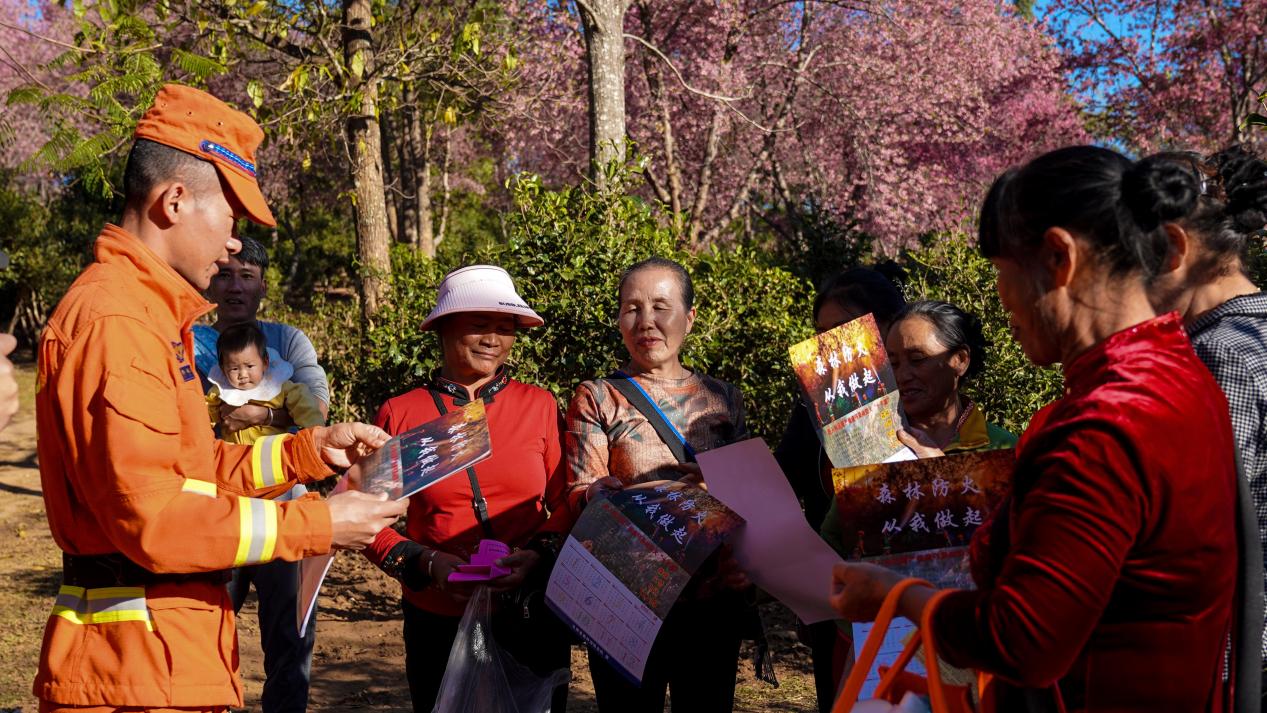 12月30日，在澜沧县景迈山，消防员给游客科普森林防火常识。郭元丰摄